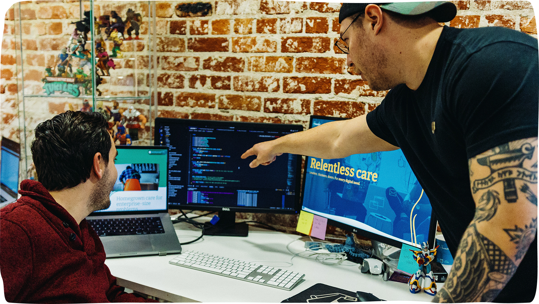 Hounder team members pointing to computer screens with code