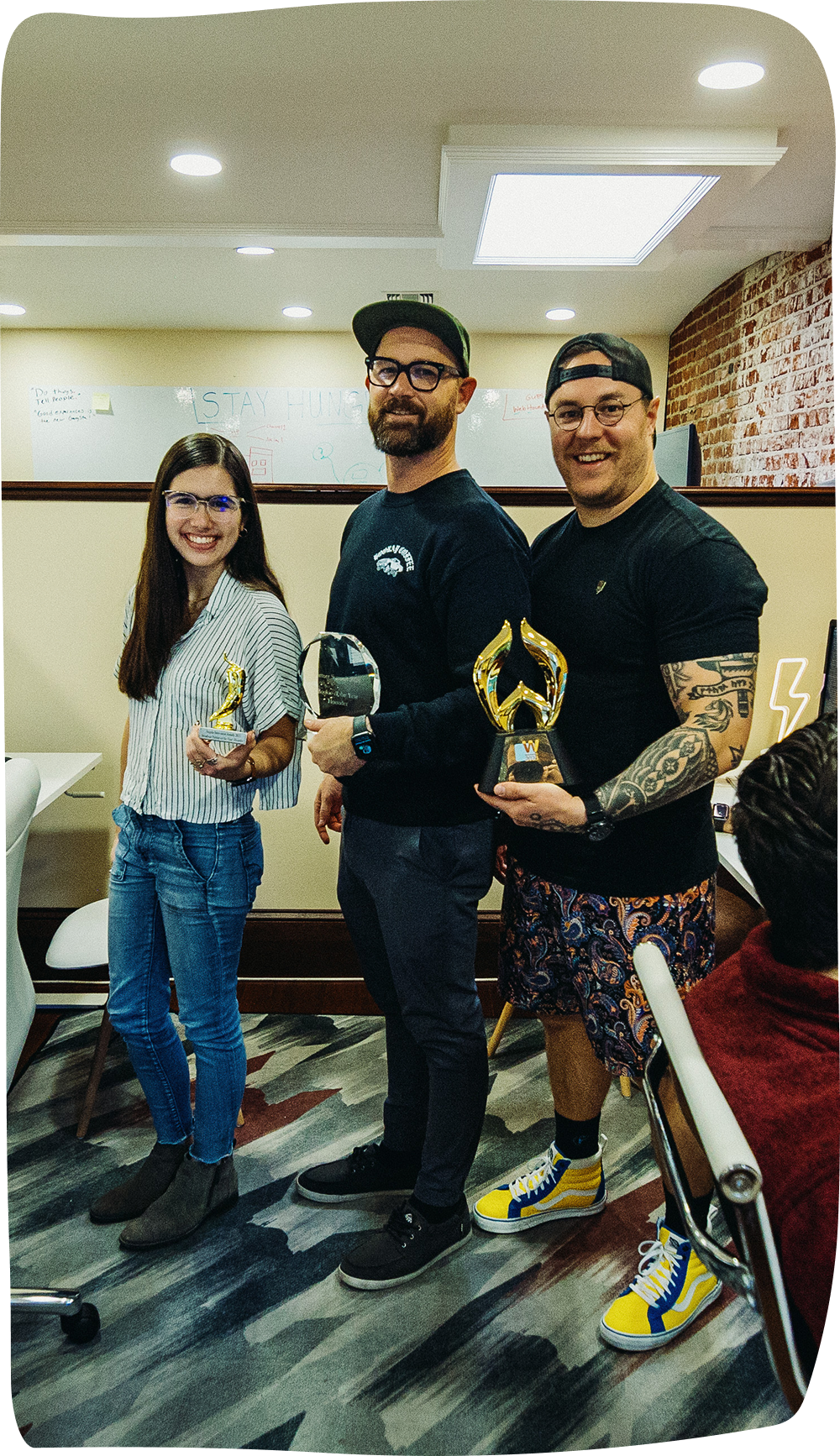 Three Hounder team members holding awards Three Hounder team members holding awards