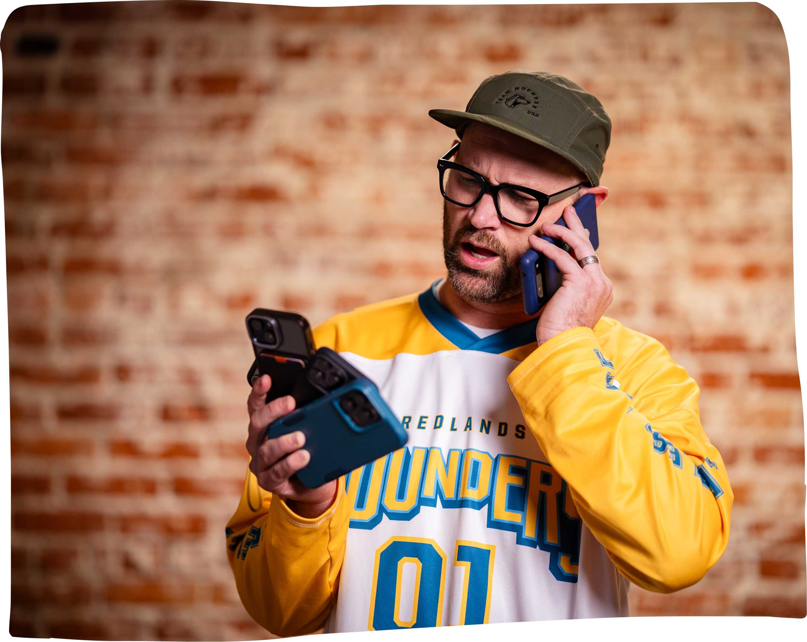 Hounder CEO holding multiple smartphones.