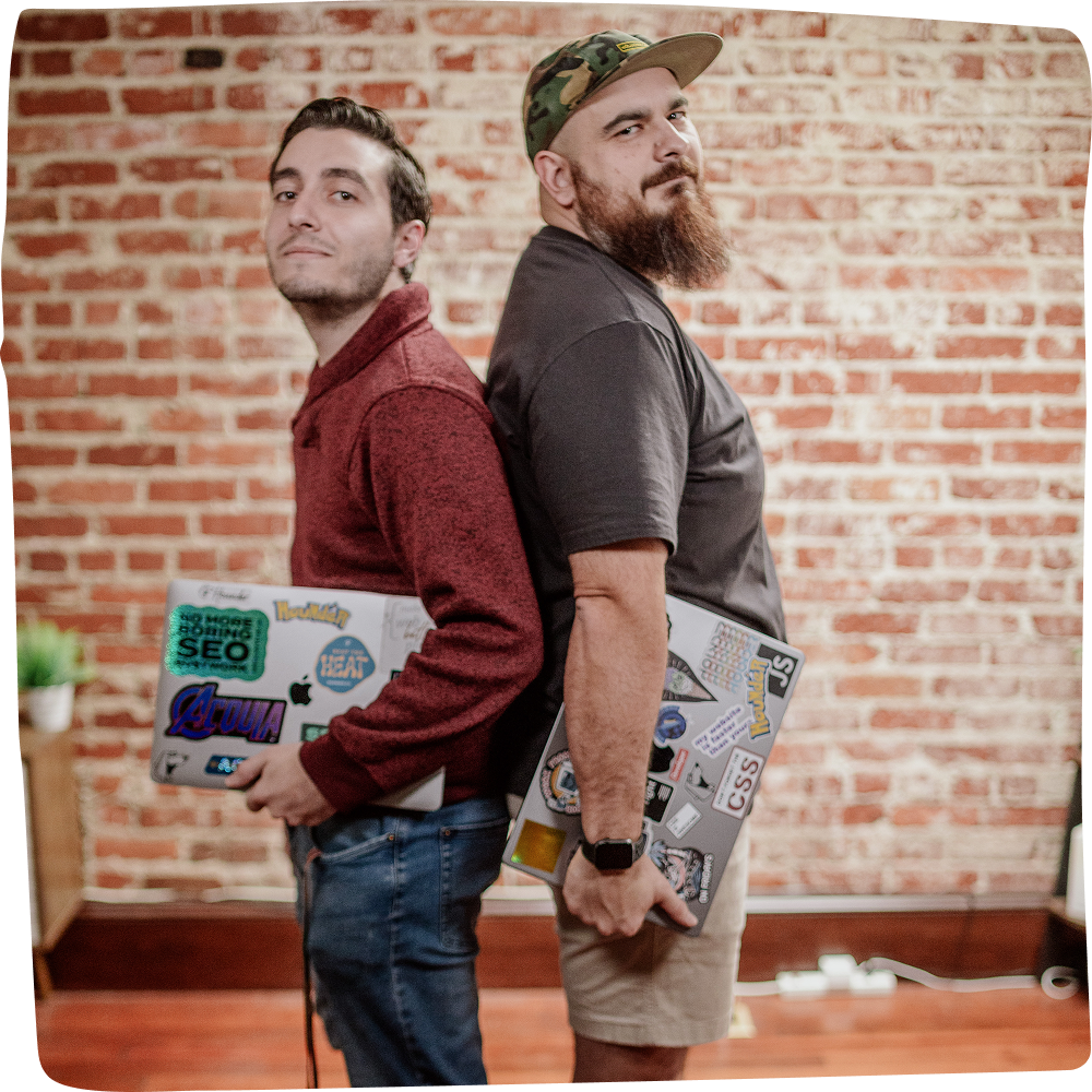 Two Hounder team members standing side by side with laptops